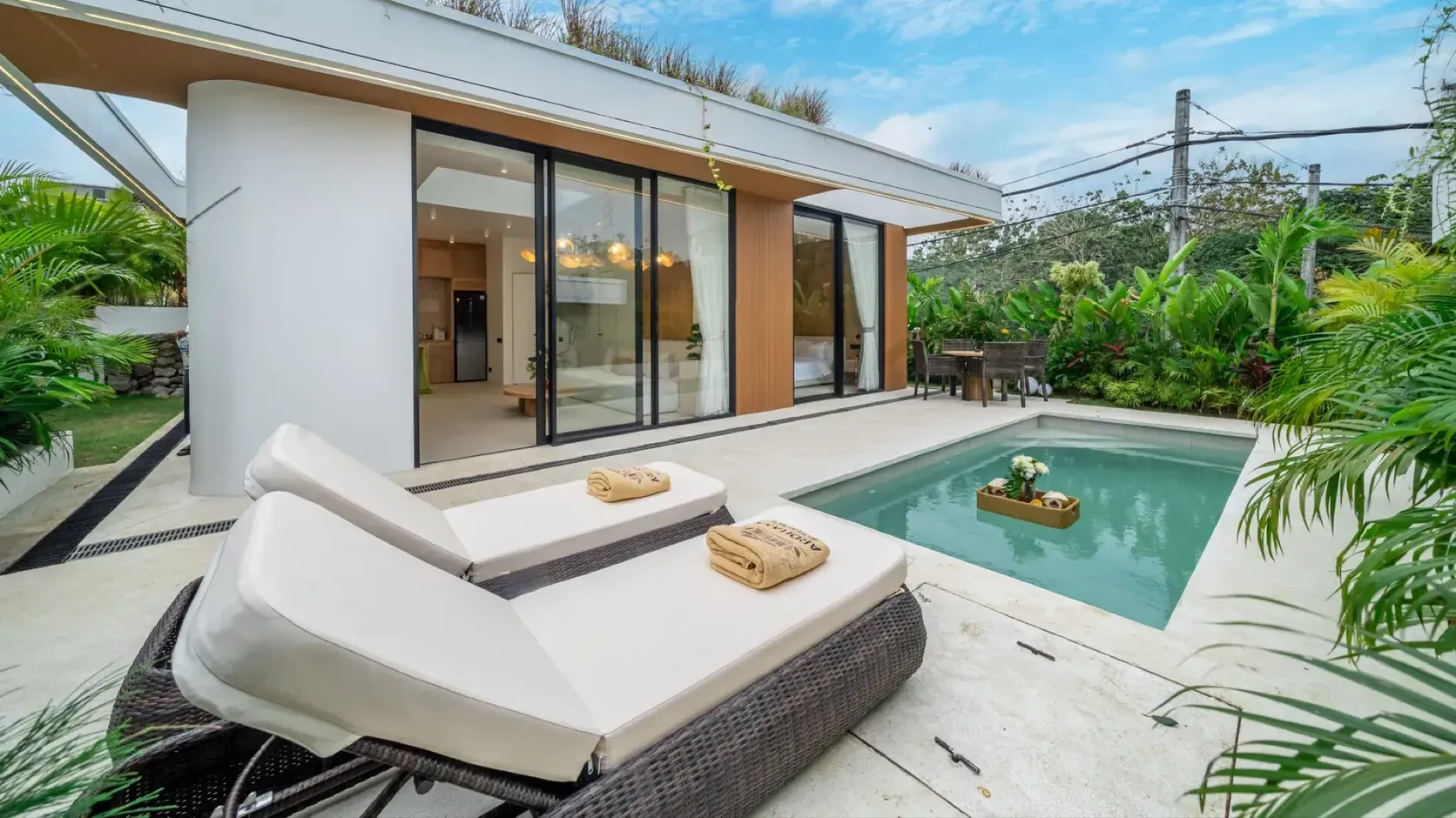 The private plunge pool of a completed Ardhana villa in Ungasan on the Bukit, with clear water, a pale stone deck and two sun loungers